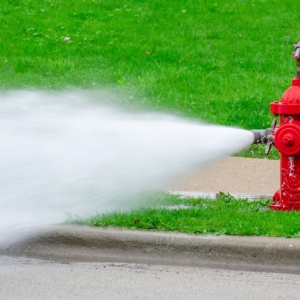 Red fire hydrant with high pressure water spray