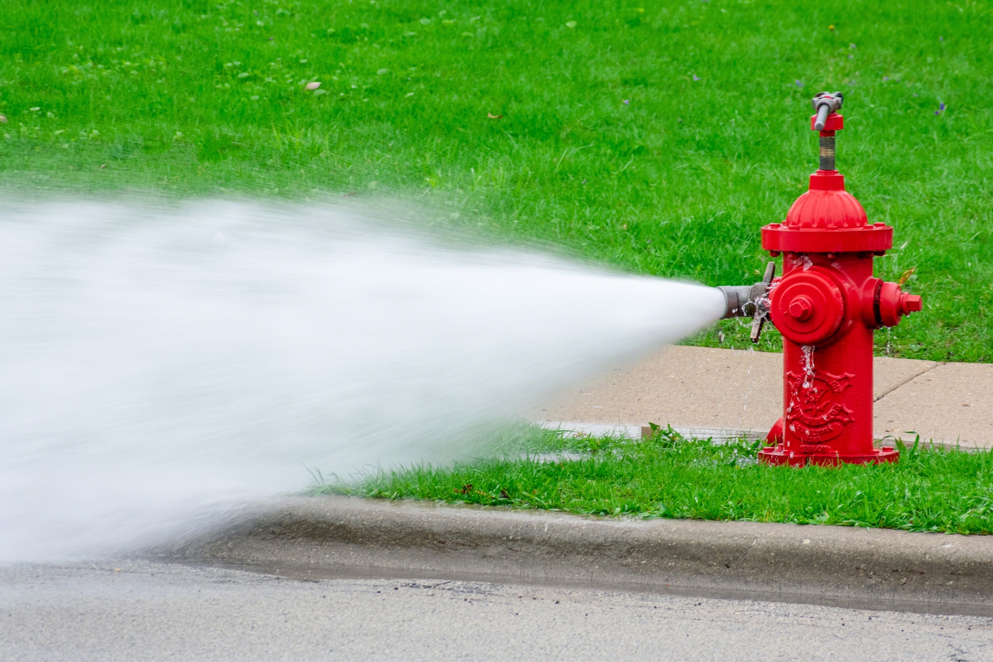 Red fire hydrant with high pressure water spray